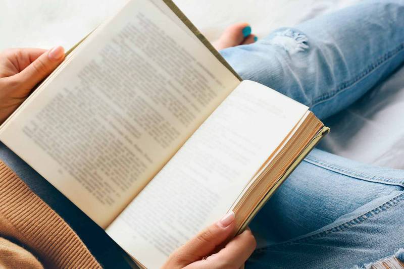 Una persona leyendo un libro recostada. EPDA.