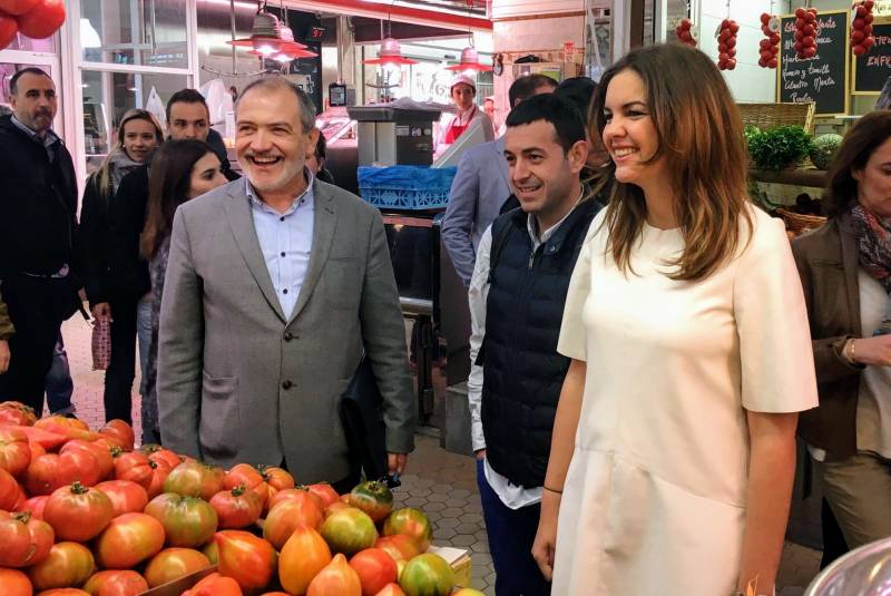 Sandra Gómez y Ricard Camarena saludando a los vendedores del Mercat Central