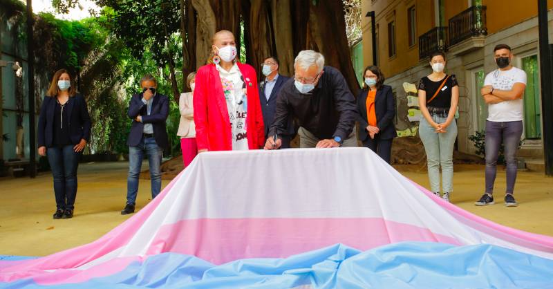 Joan Ribó signant la bandera trans. EPDA