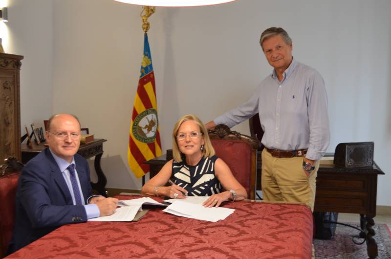Juan Sabater y Amparo Fabra firman el convenio en presencia del Presidente del Colegio del Arte Mayor de la Seda