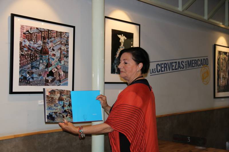 Pepa Gómez mostrando el libro del fotógrafo Abella